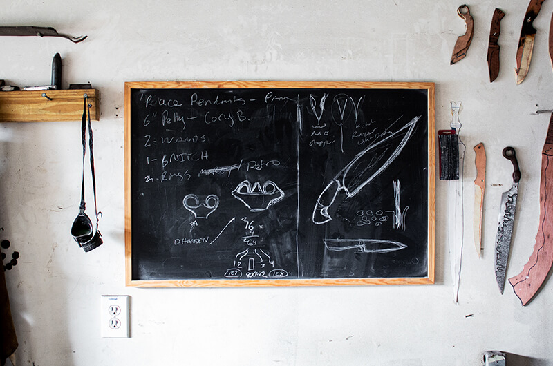 Chalkboard and knives on wall in artist studio